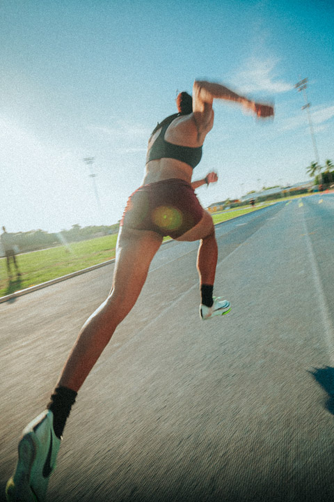 a runner is shown from behind taking off from the starting block