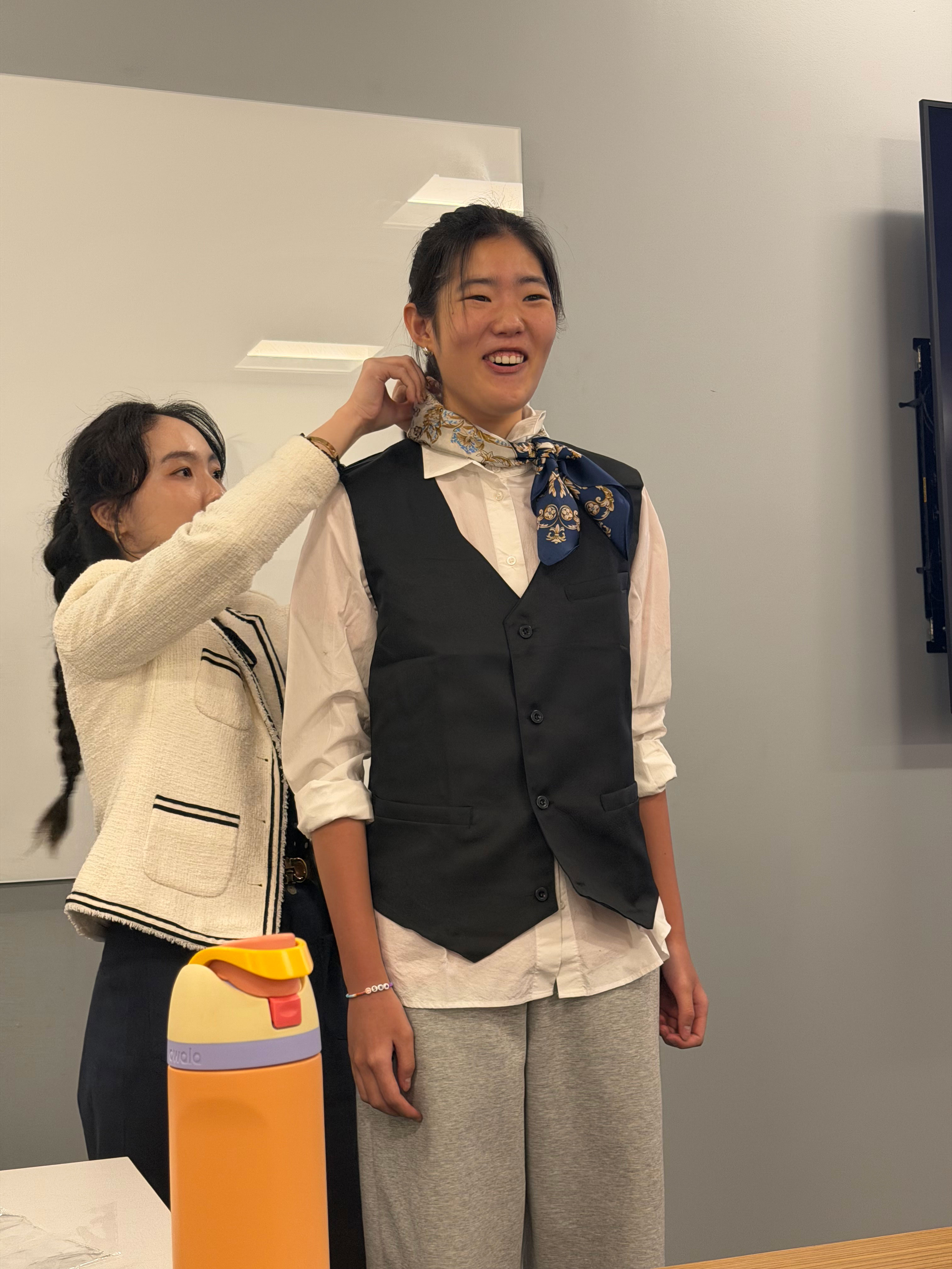 a woman puts the finishing touches on a servers outfit.