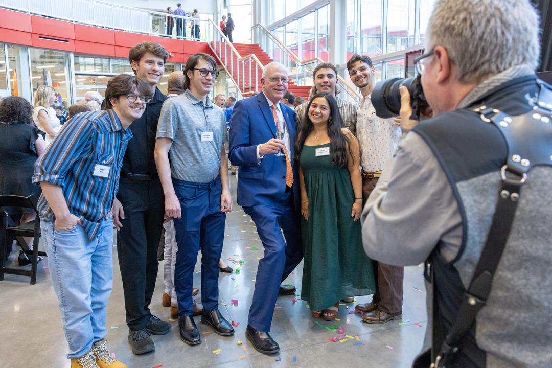 A photographer takes a picture of a group of people standing together
