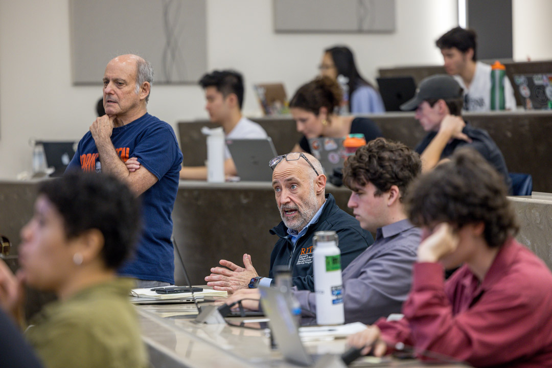 people of various ages sit in a modern college classroom