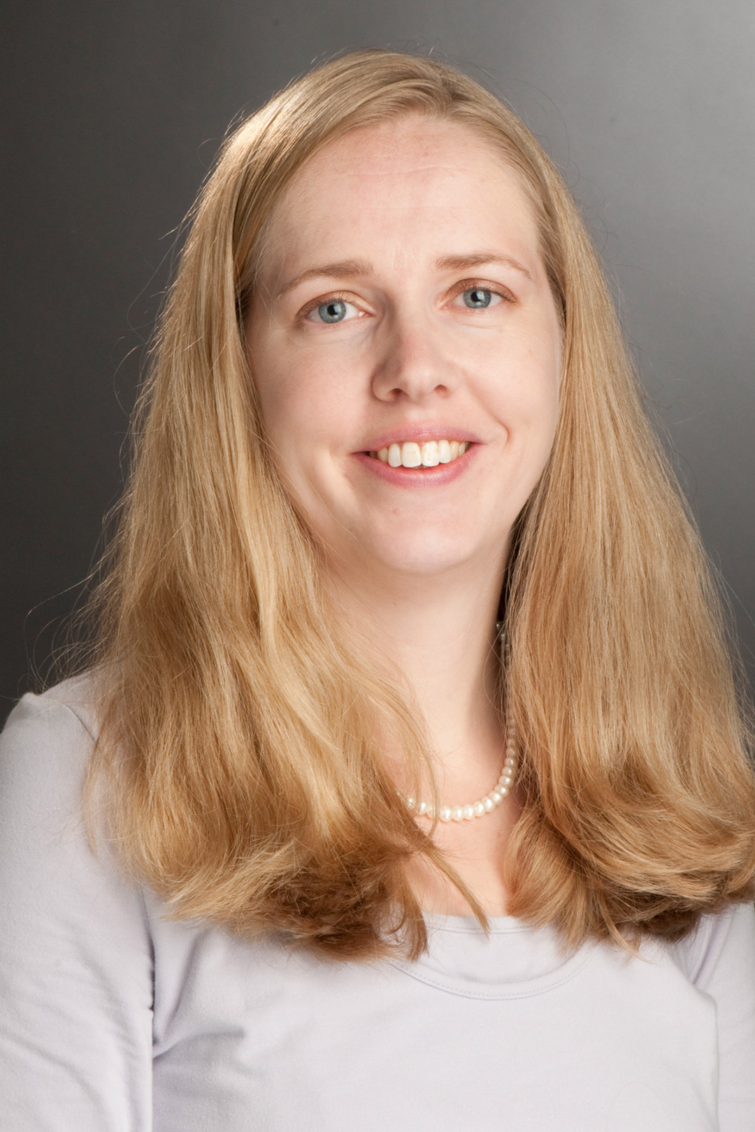 a blonde woman sits for a headshot.