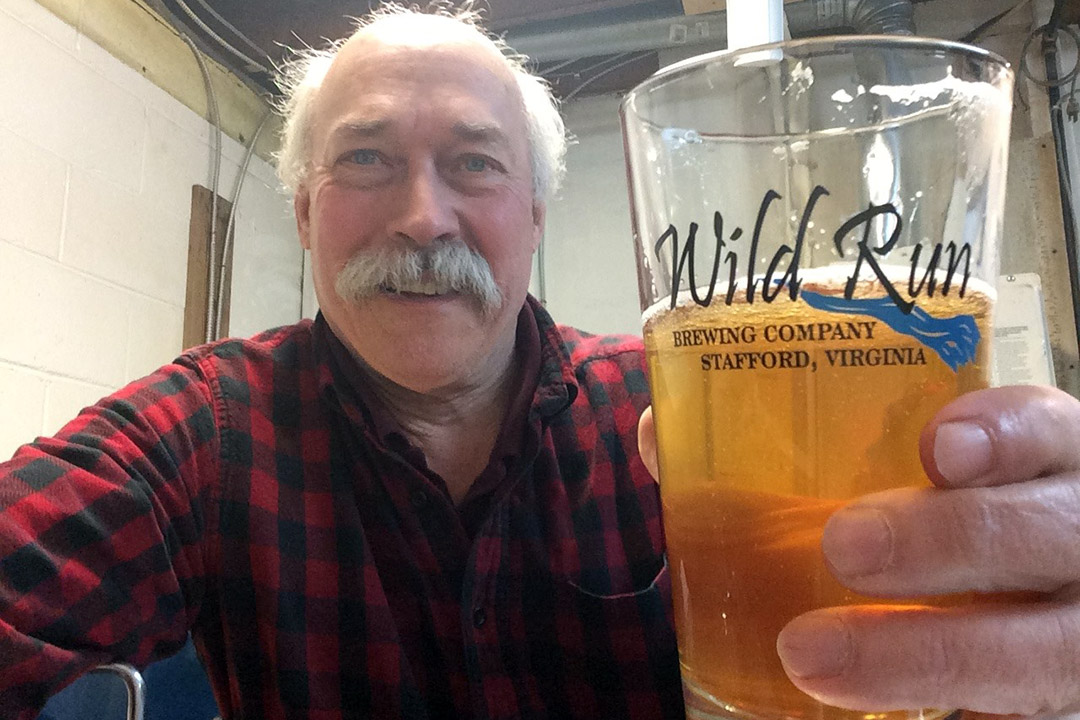 man holding glass of beer.