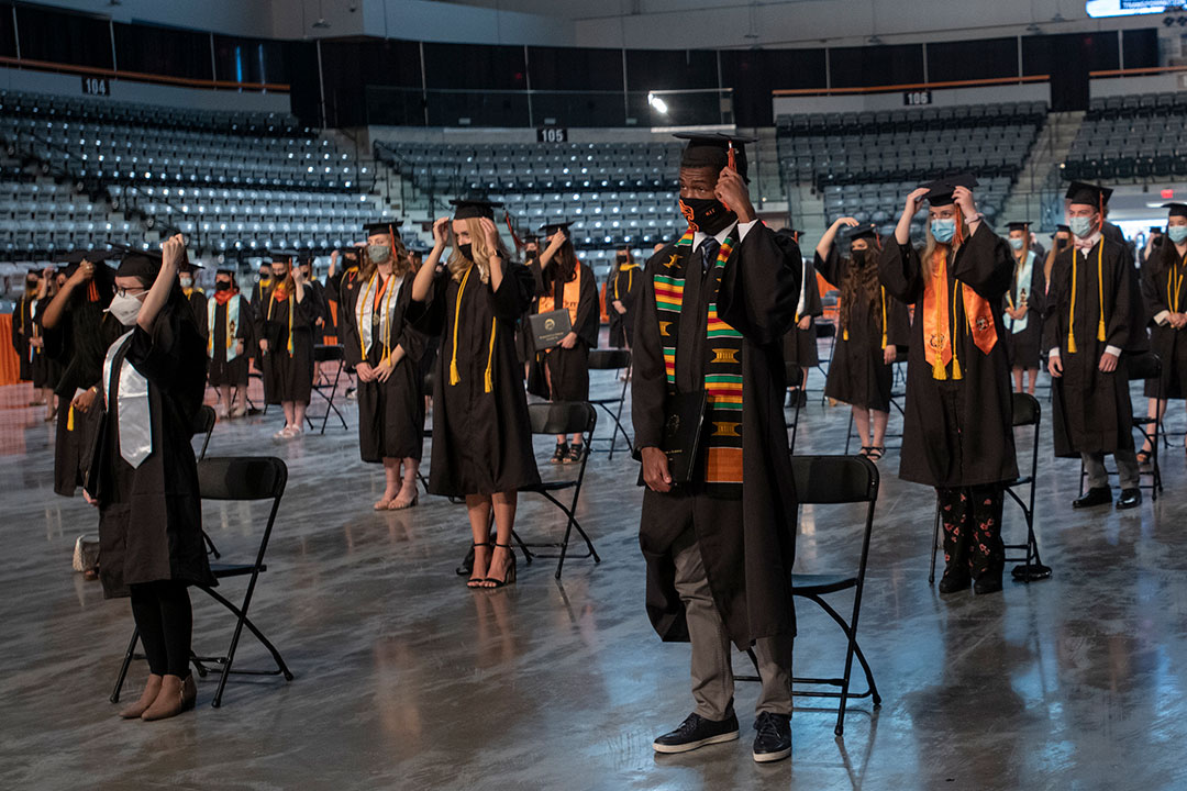 Graduates turn tassel on their graduation caps.