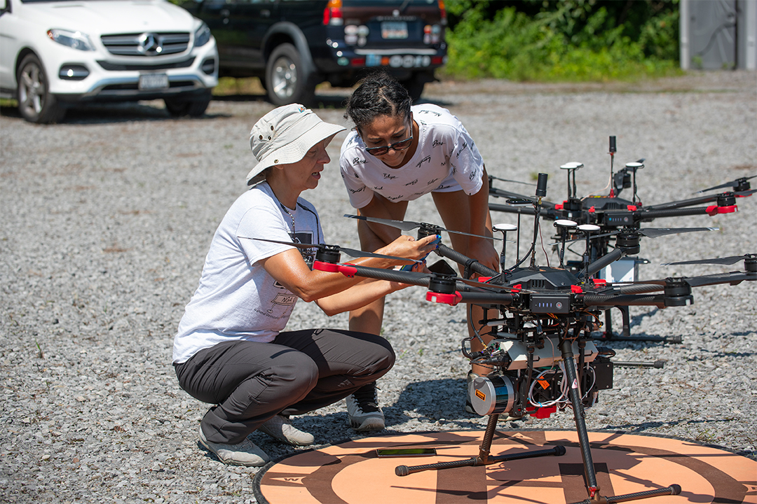 Two researchers work with a drone.