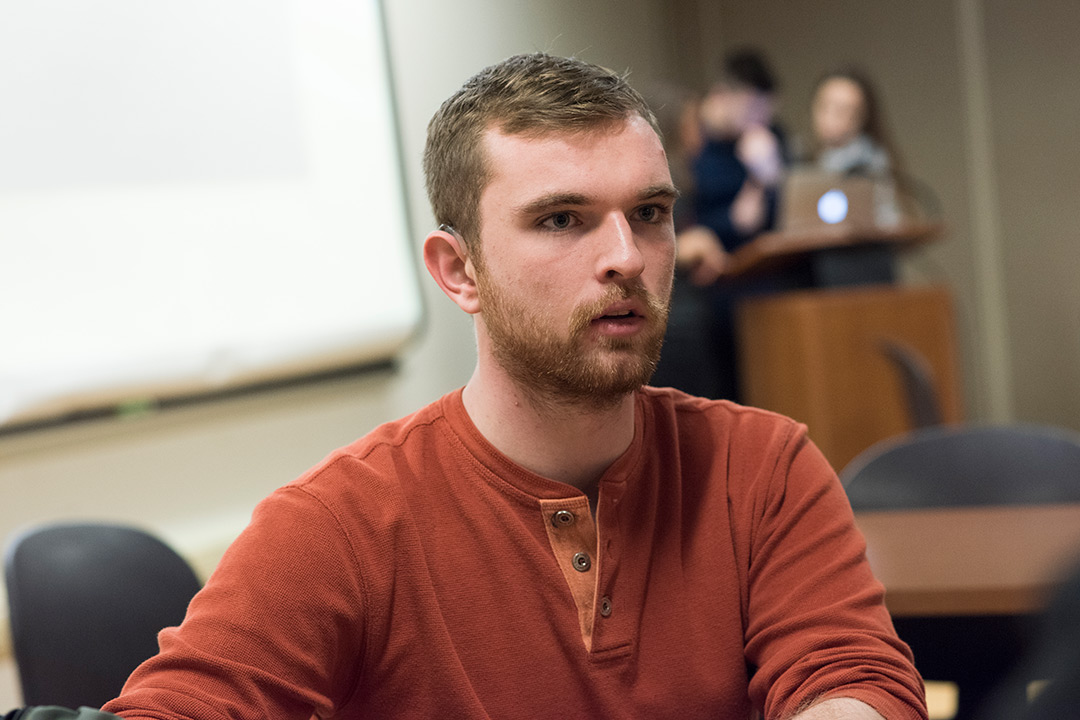 Male student wearing orange sweater