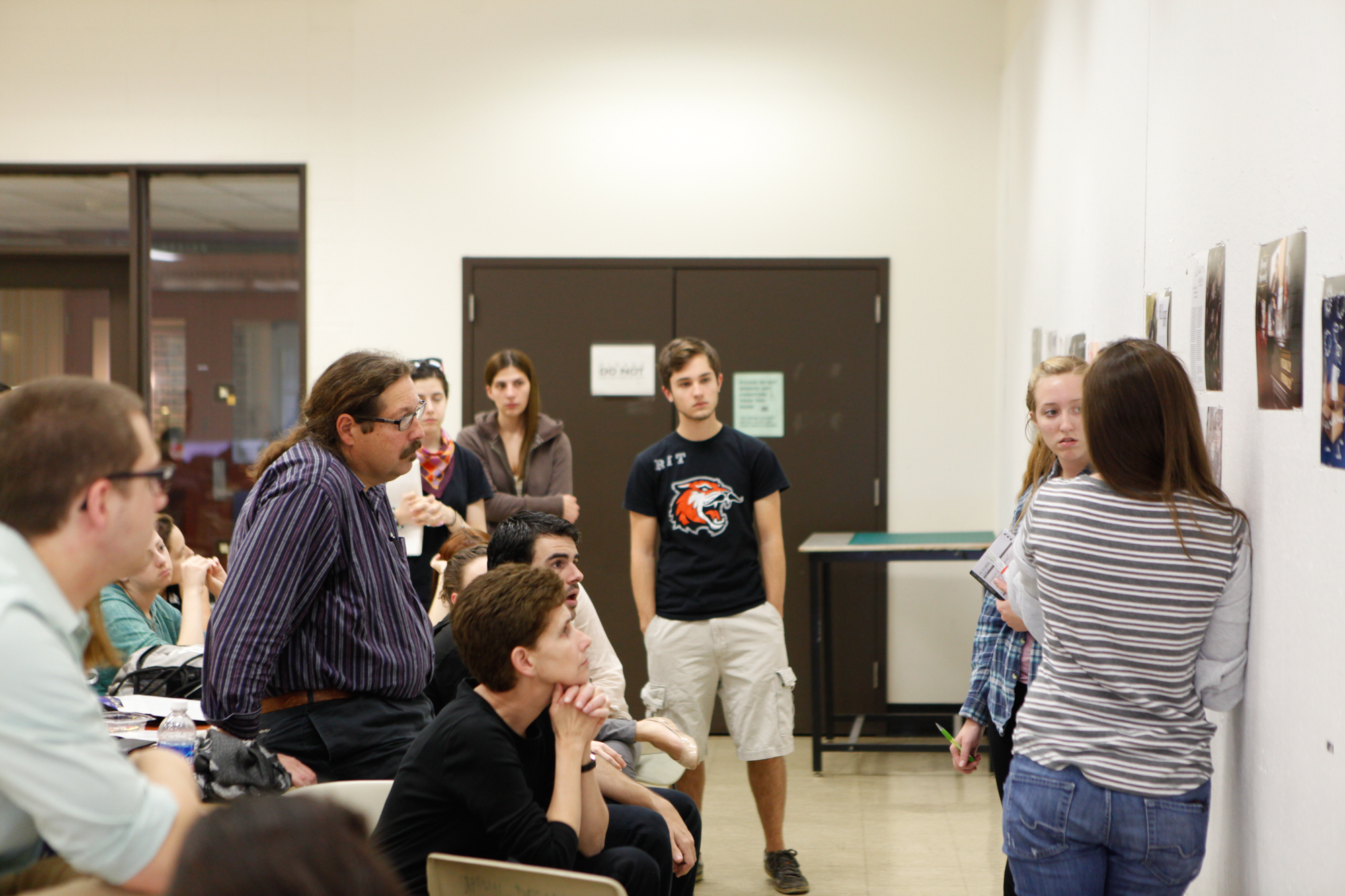 A group of students and professors in a classroom critiquing the magazine