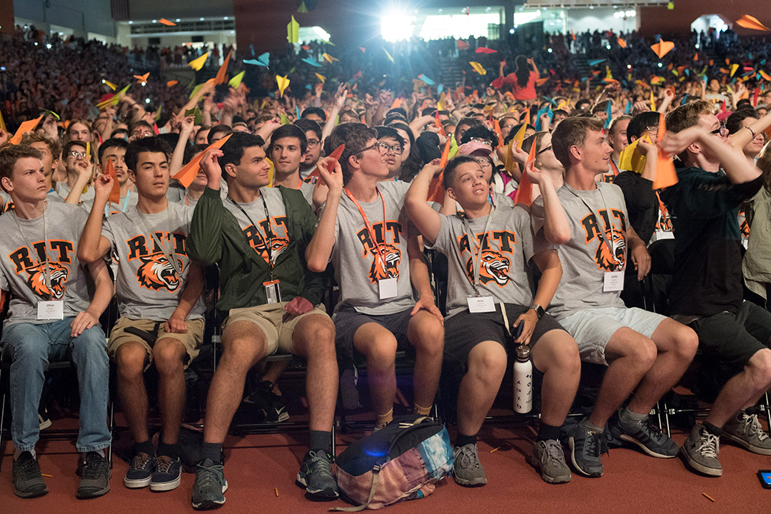 Row of seated students throws paper airplanes.