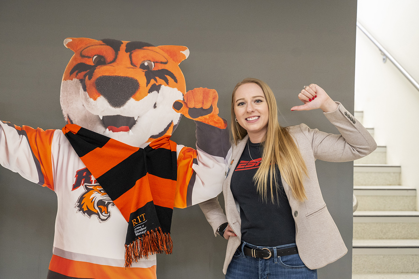 Becky Yaeger next to a large RIT Tiger RITchie cutout.