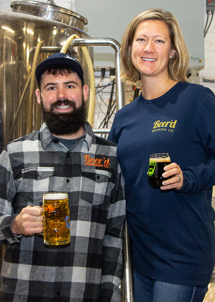 man and woman holding glasses of beer.