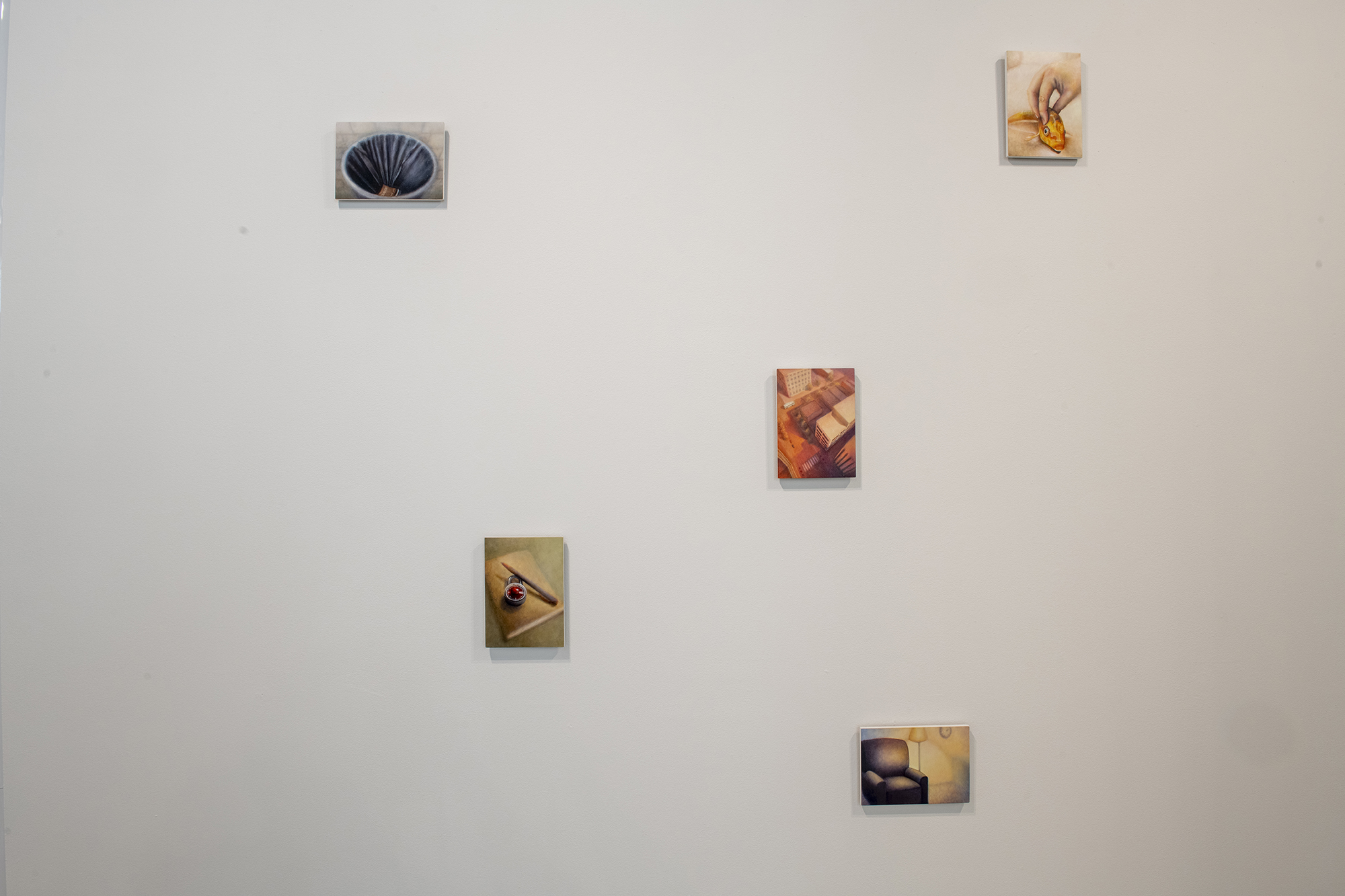 A series of small paintings on a wall.