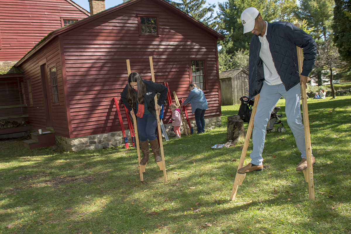 Two RIT students walk on stilts at the Genesee Country Village and Museum's annual fall fair.