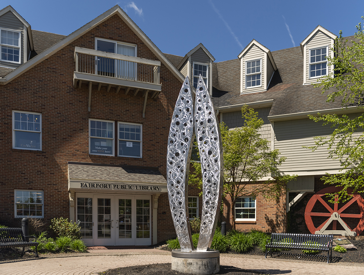 The "Connection" sculpture stands tall outside of the Fairport public library.