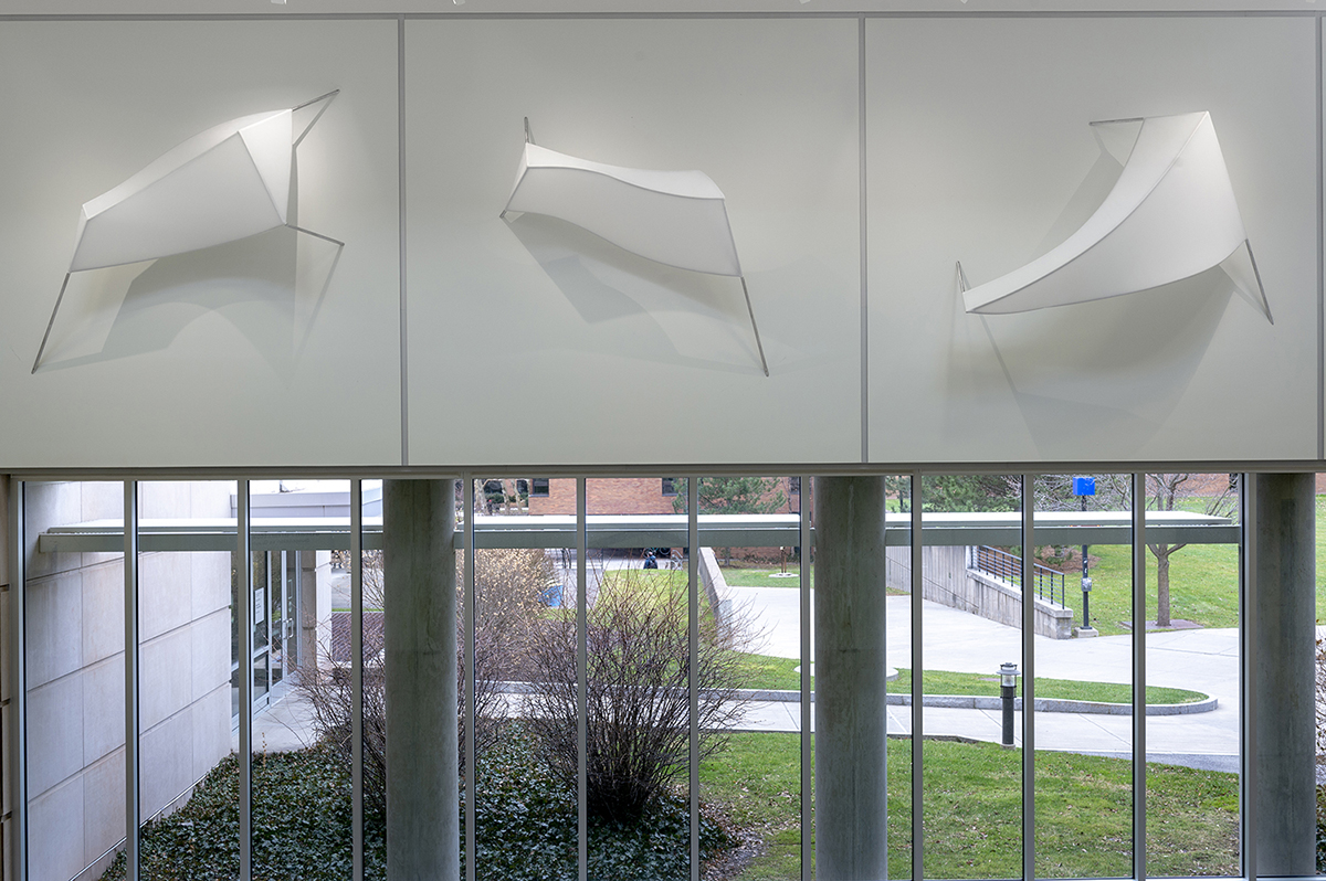 Three large fiber sculpture suspended on high walls.