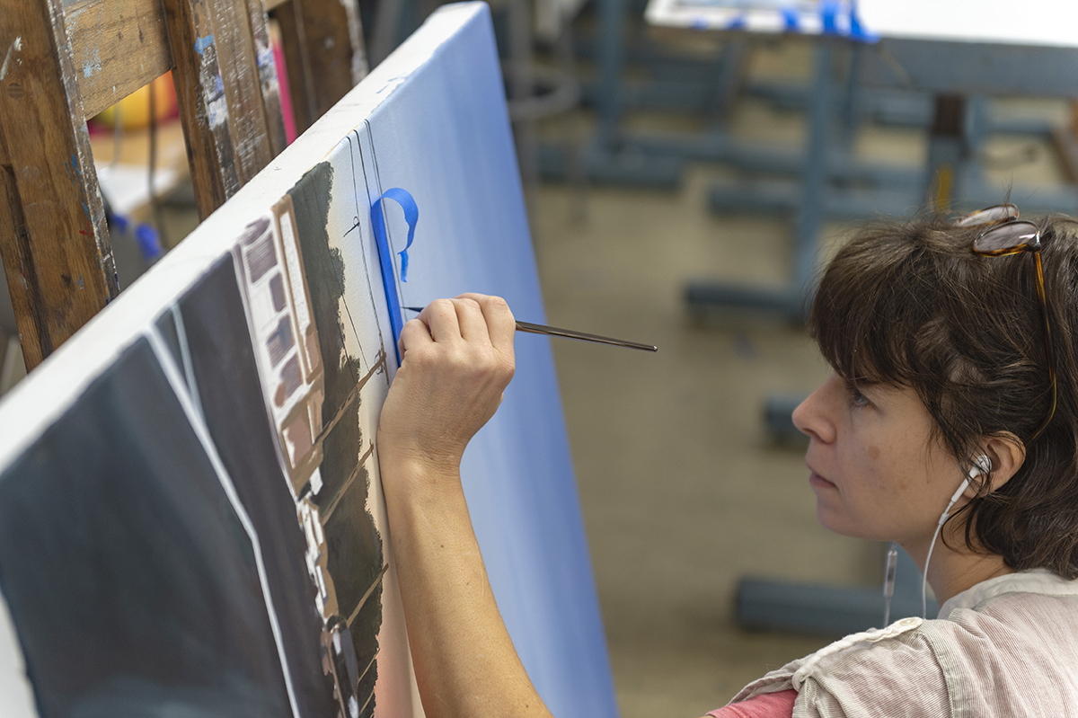 A student paints in the studio.