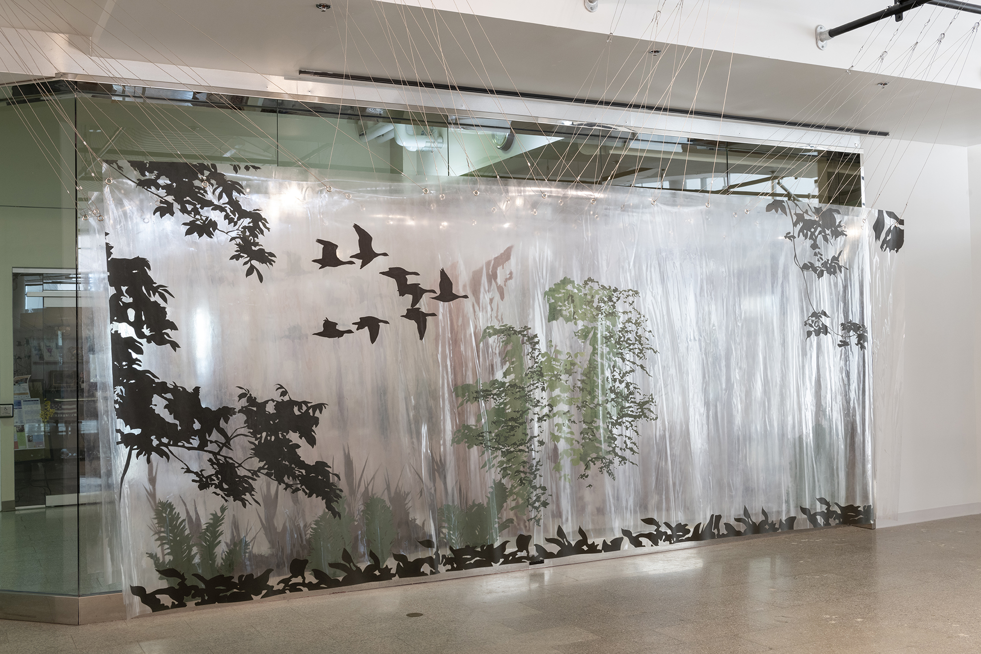 An installation piece that shows silhouettes of birds and trees.