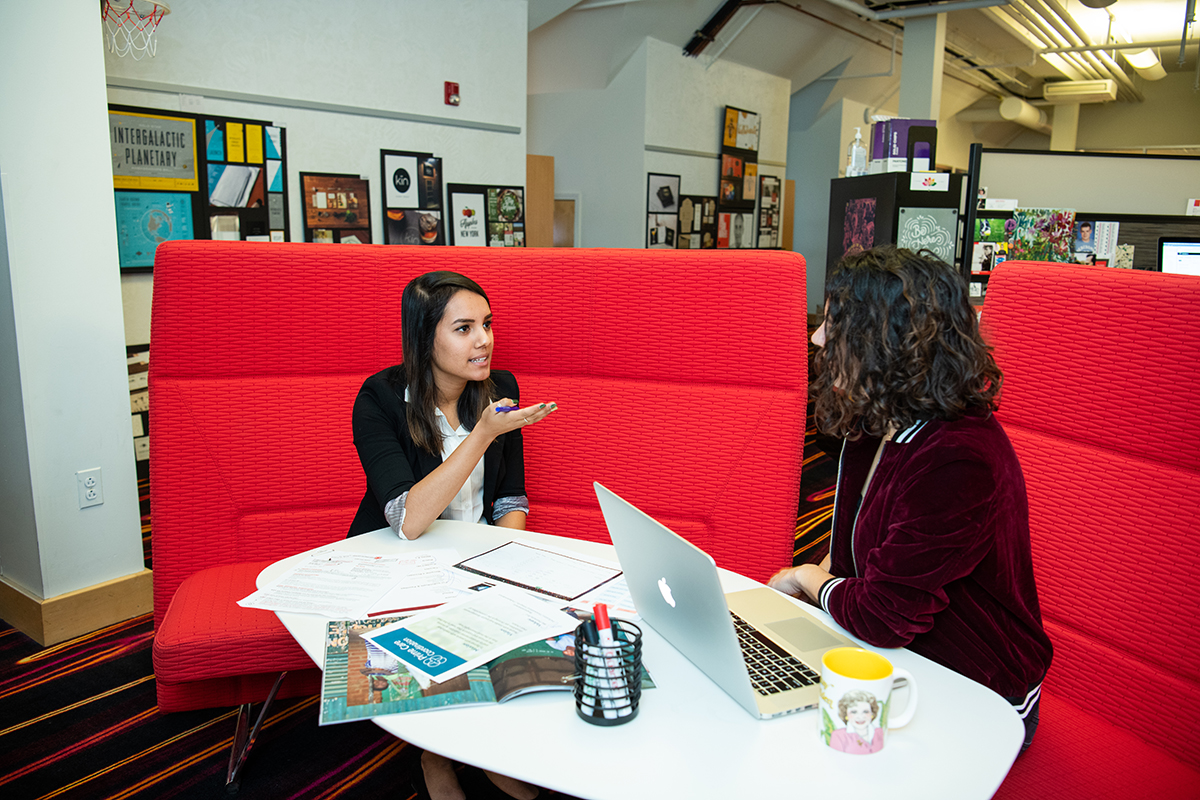 Isha Mehta and a fellow Dixon Schwabl employee talk.