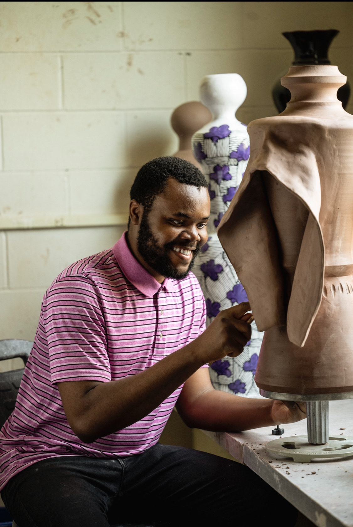 Emmanuel Okechukwu slip trails in the ceramics studio.