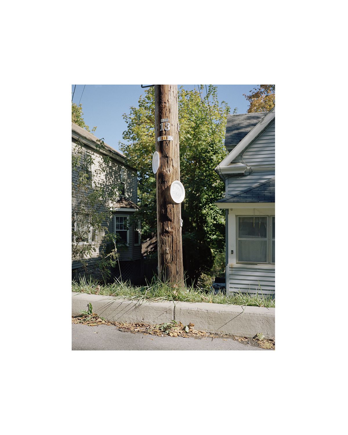 A photo of an electrical service pole between two houses.