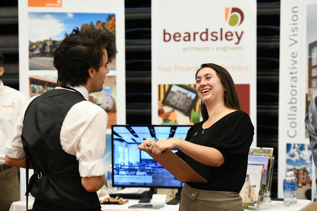 recruiter at job fair talking to a student.