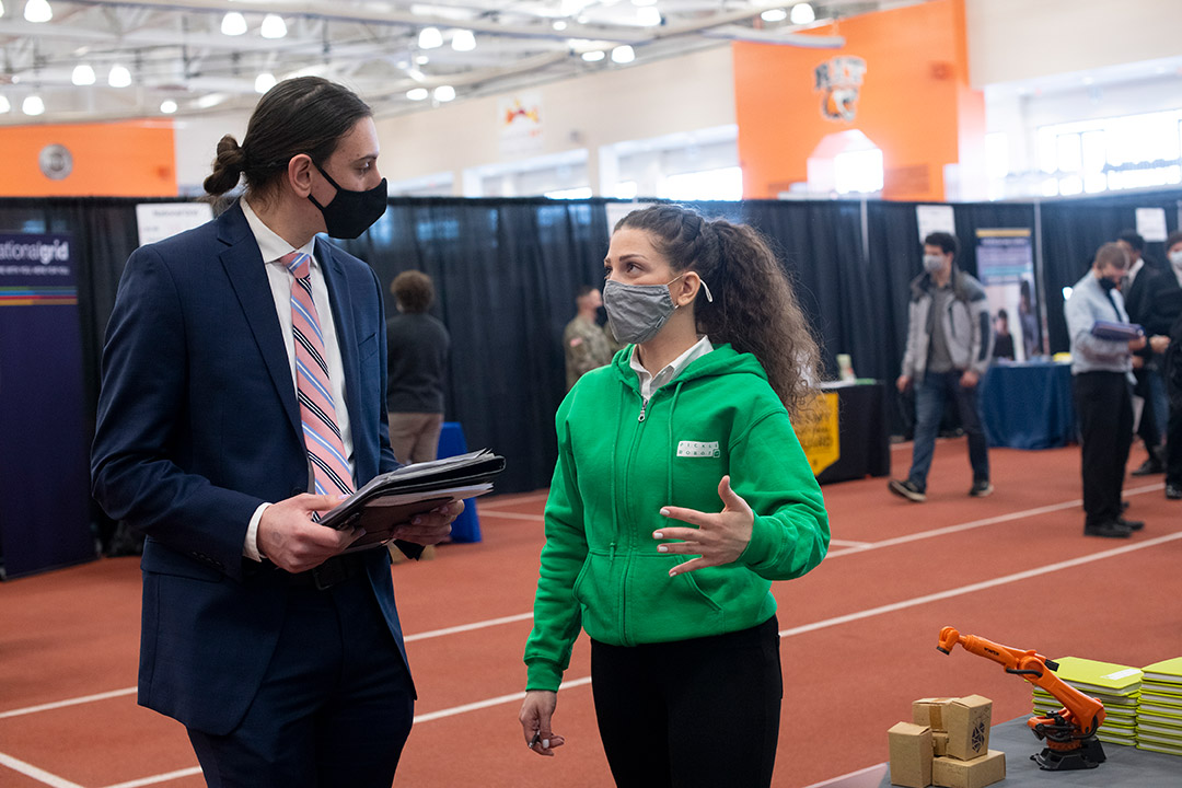 student and employer talking at a career fair.