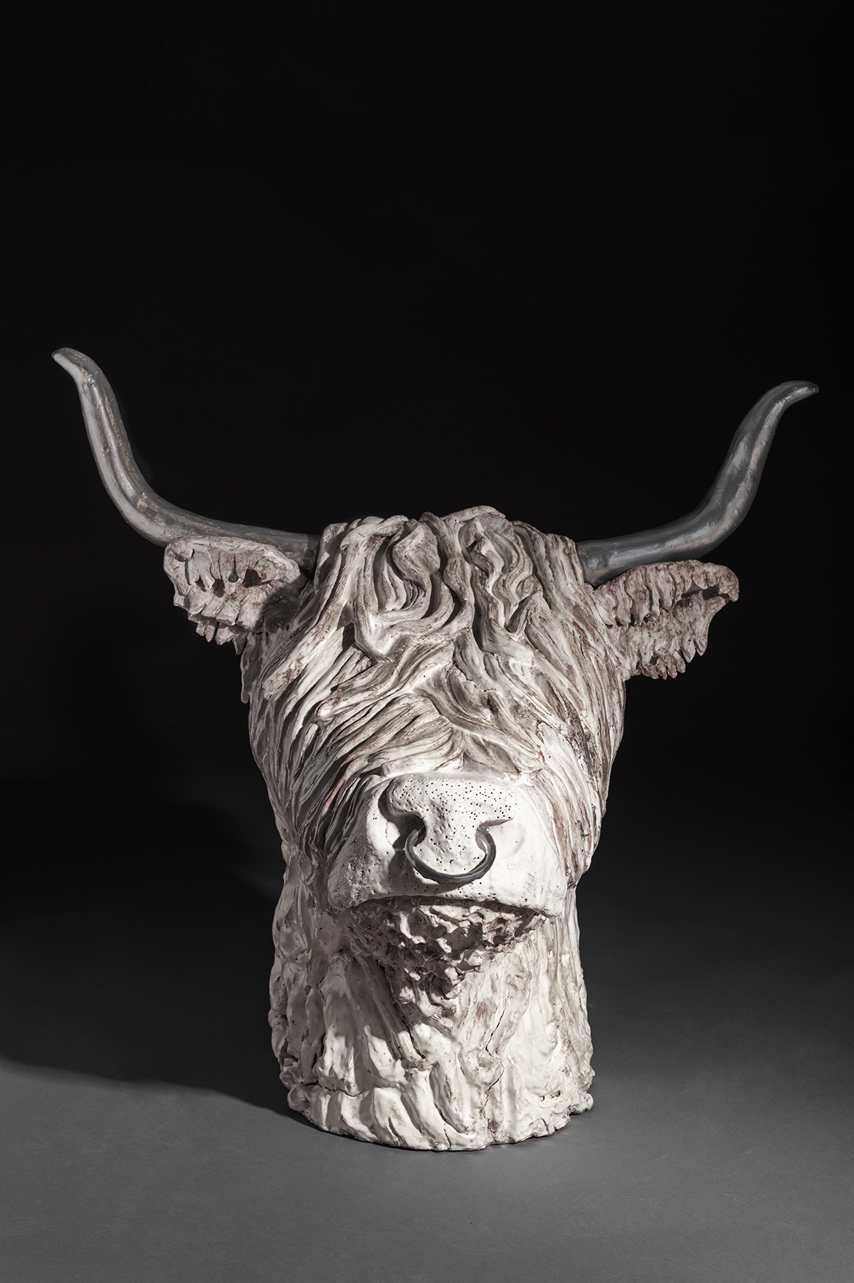 A ceramic sculpture of a bull with horns.