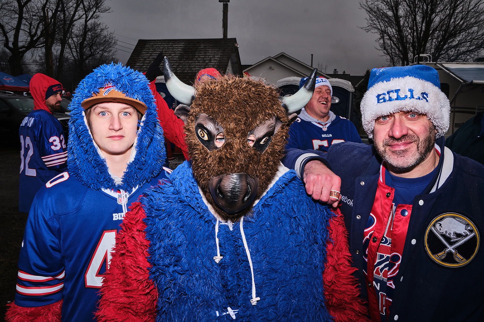 Bills fans, one wearing a Buffalo mask, pose for a portrait.