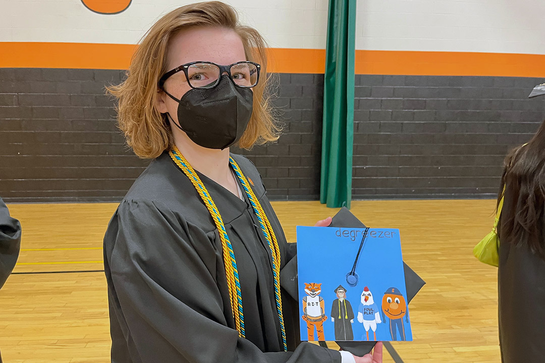 graduating student holding her mortarboard.