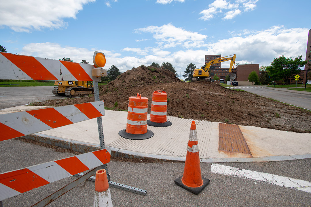 a newly poured concrete sidewalk with safety cones blocking it off.