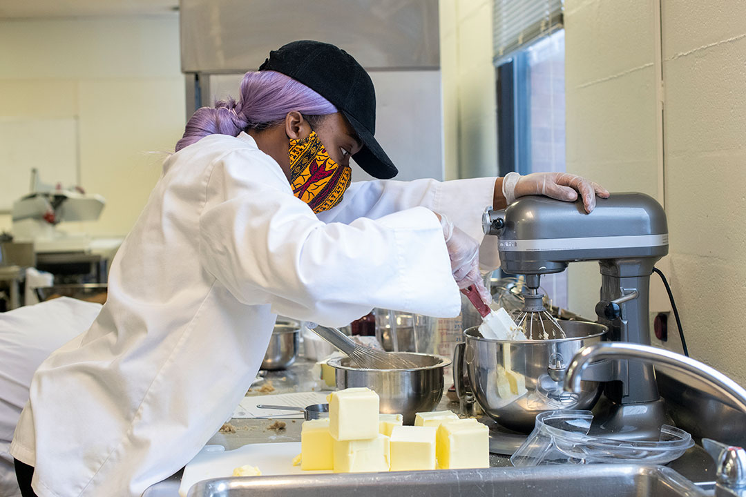 student using a stand mixer.