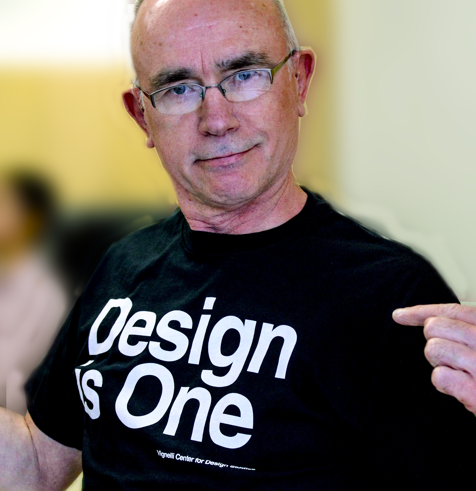 A photo of Stephen Scherer wearing a shirt that says Design is One.