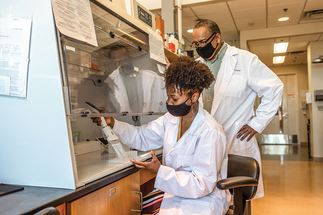 student and researcher working in a lab.