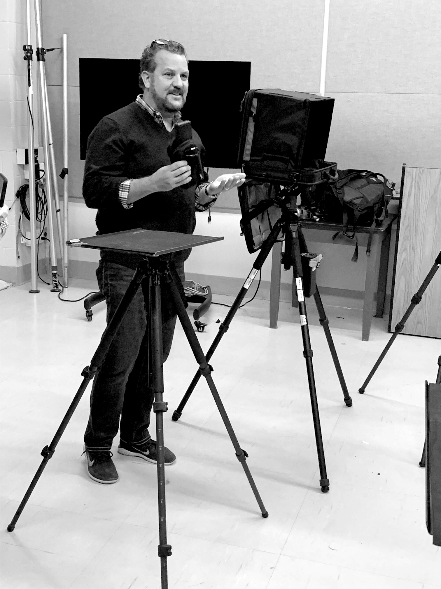 Dave Gallagher stands next to photography equipment.