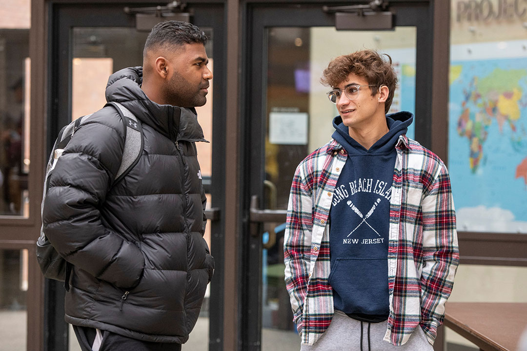 two students standing and talking.