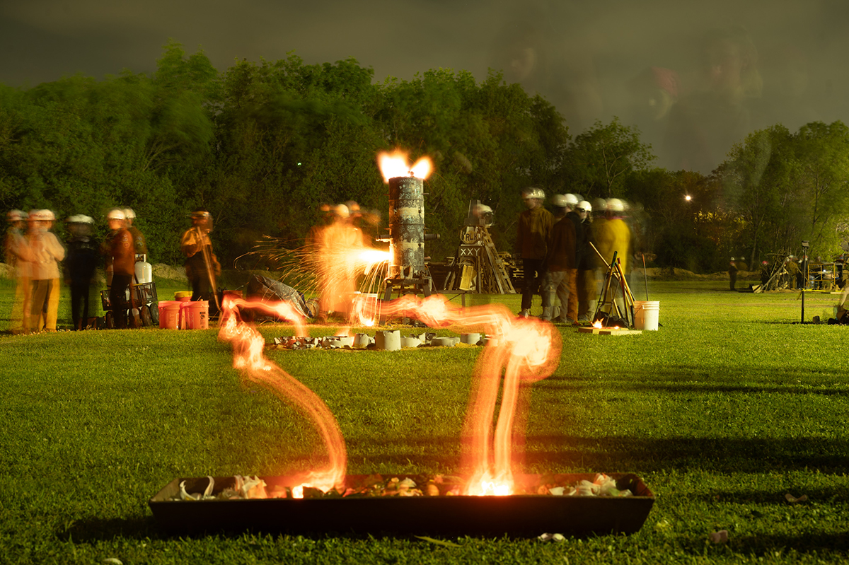 An extended exposure look at molten iron filling molds during a performance.