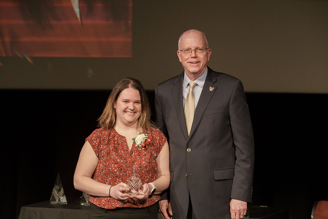 award winner and President Munson posing on stage.