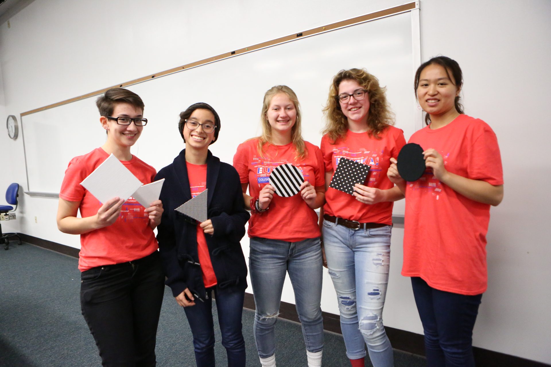 A group of five students stand side by side.