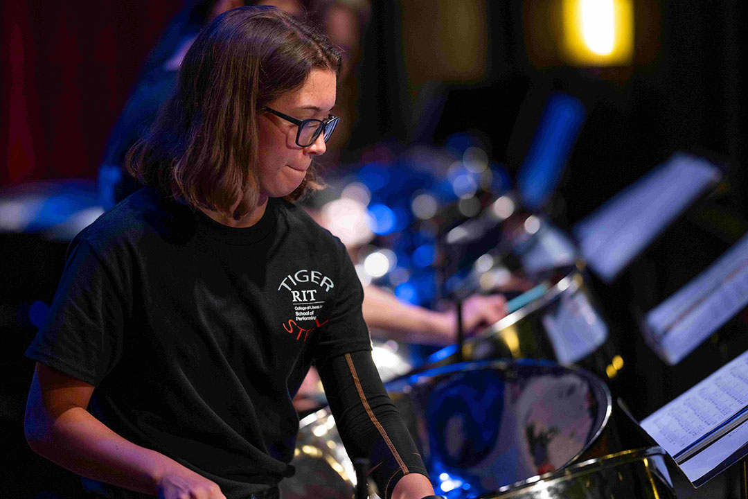 college student playing a steel drum.