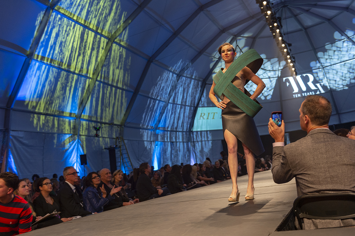 An alumna walks the runway in her wearable sculpture.