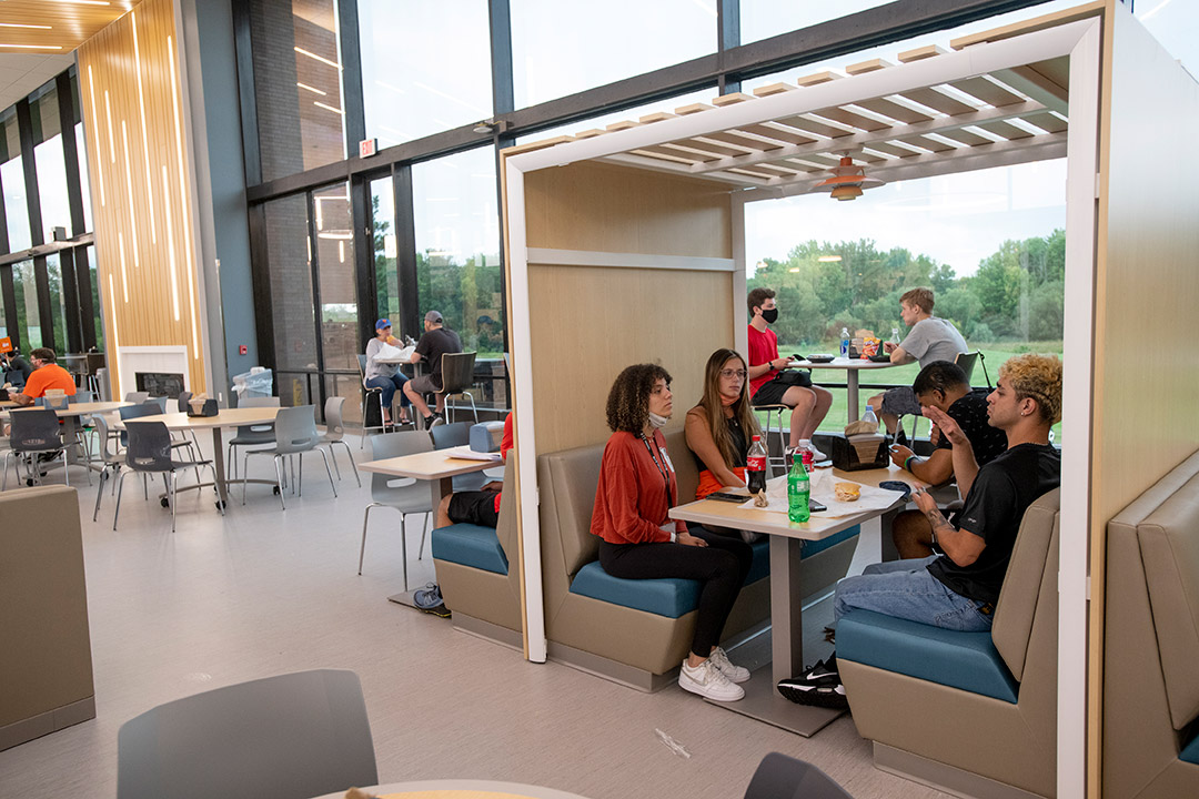 students seated in a booth in a renovated dining hall.