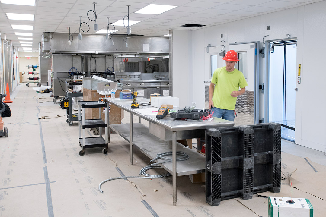 Contractor works on table in dining hall.