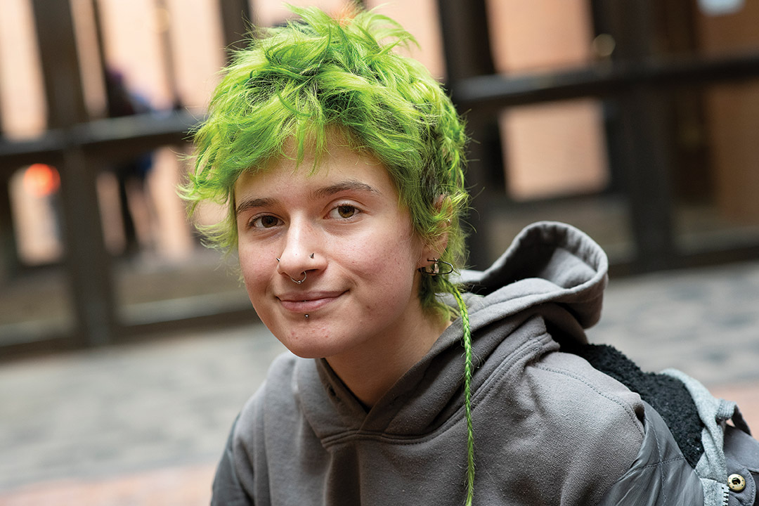 student with neon green hair and a rat tail.