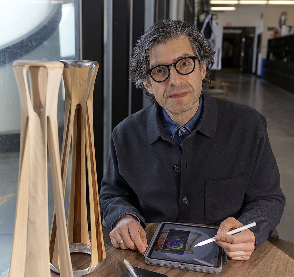 Alex Lobos holds a pen and tablet.