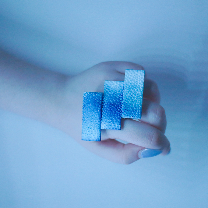 3D-printed jewelry — a blue ring with three bars.