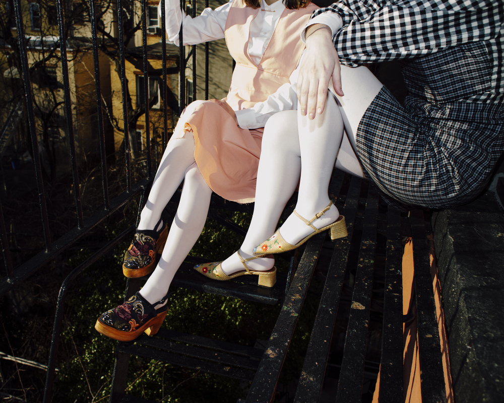 A photo of two people sitting on an outdoor stairwell.