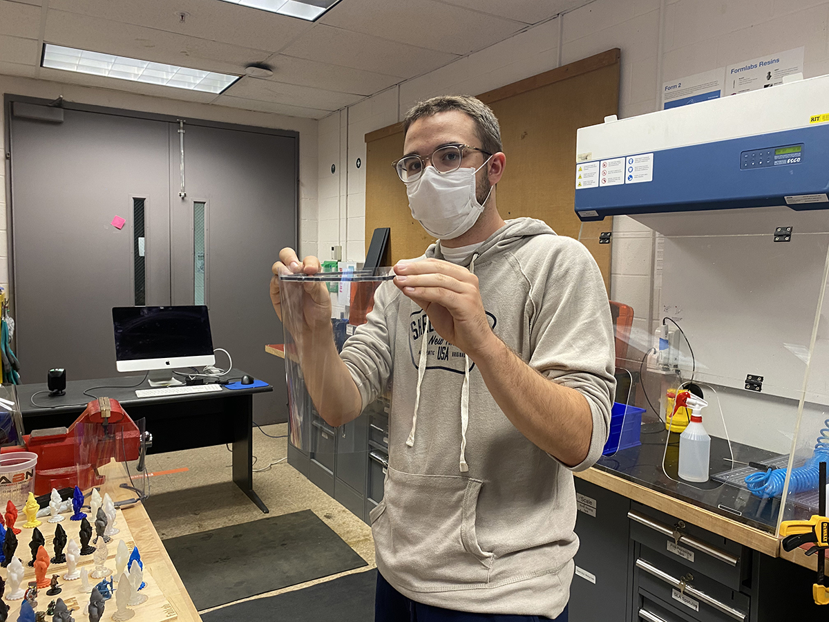 Mike McNaught holds up a transparent shield created in the Fab Lab.