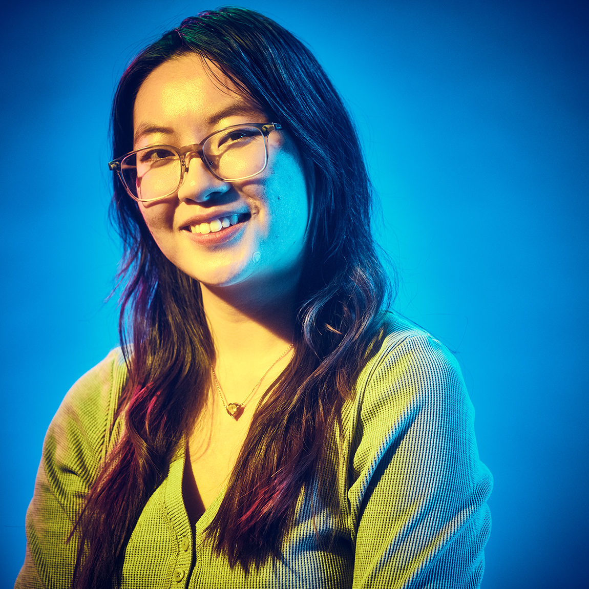 A portrait of Melanie Ng on a blue background.