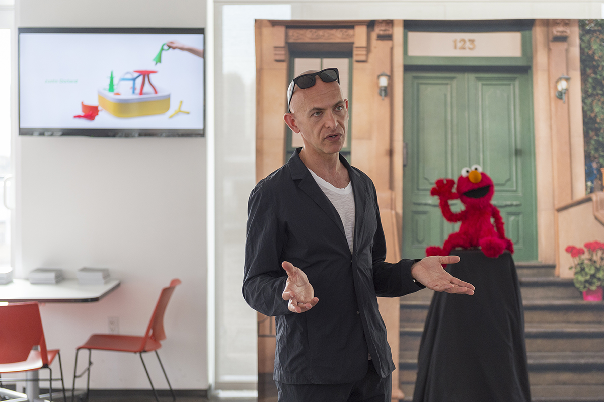 Josh Owen speaks in front of an Elmo doll