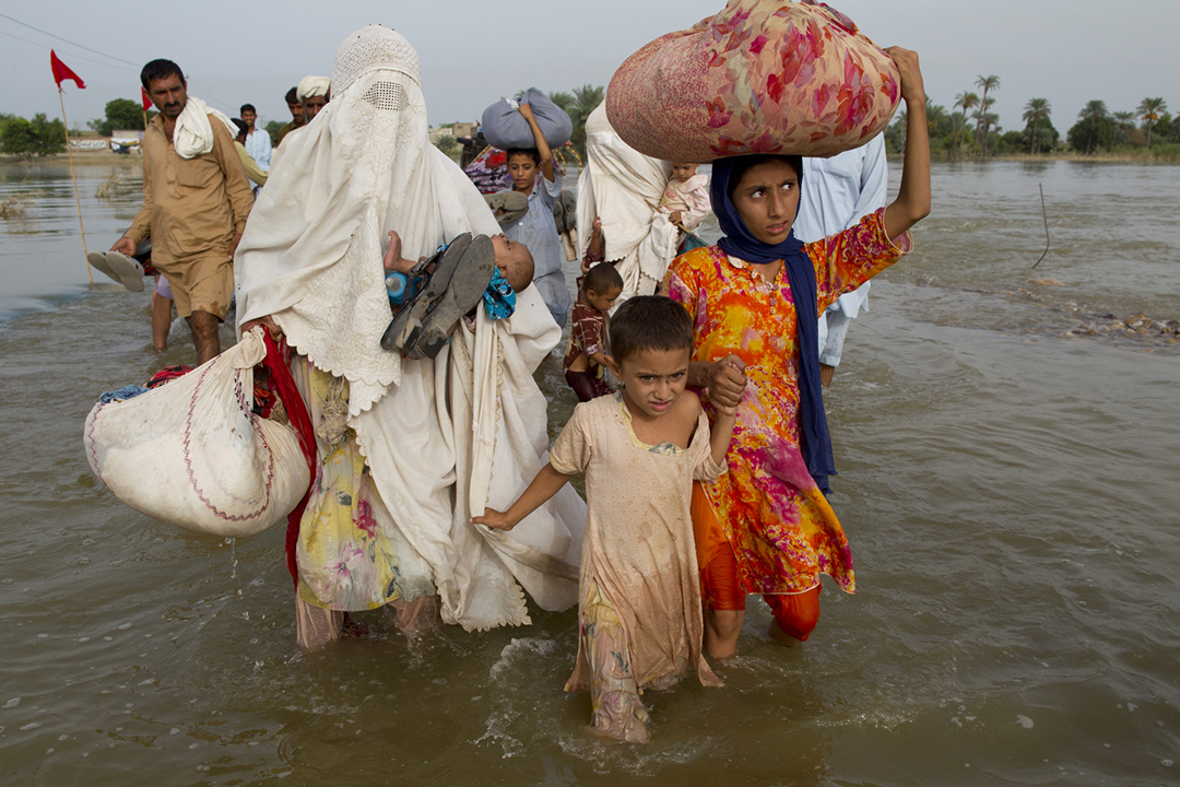 Flood victims make their way along a flooded road