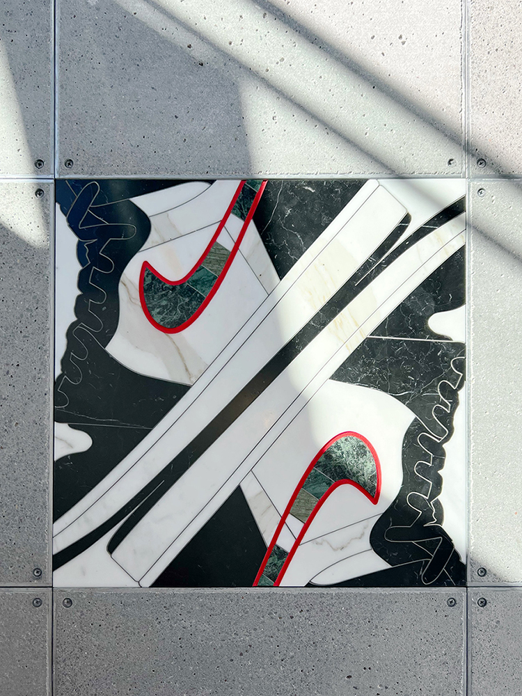 A marble inlay of Nike sneakers on the ground.