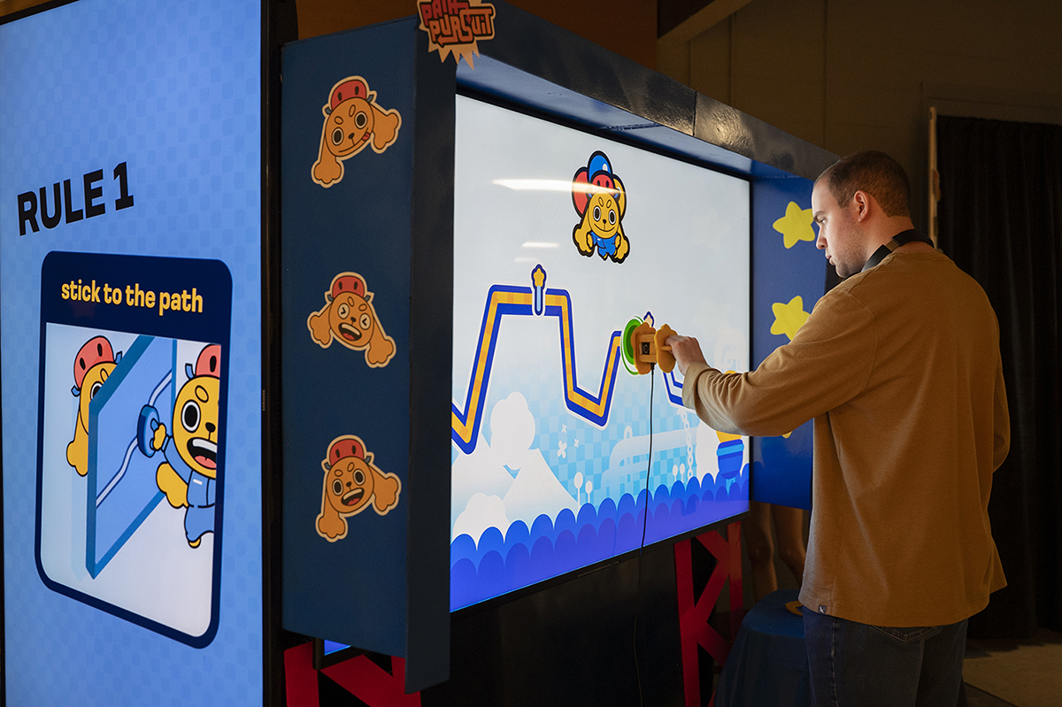 A user plays an interactive arcade-style video game at Imagine RIT.